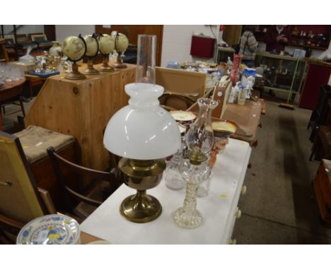A brass oil lamp with milk glass shade; and a glass oil lamp