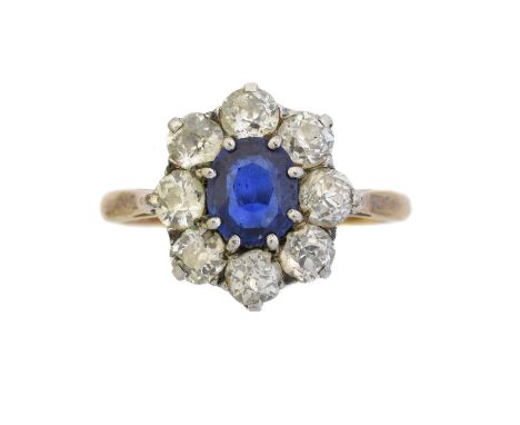 An 18ct gold sapphire and diamond cluster ring, the oval shape sapphire doublet within an old cut diamond surround, estimated