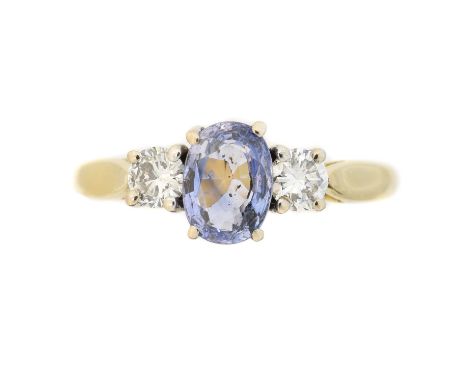 An 18ct gold sapphire and diamond three stone ring, the oval shape sapphire with brilliant cut diamond sides, estimated total