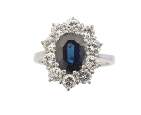 An 18ct gold sapphire and diamond cluster ring, the oval shape sapphire weighing approx. 2.25cts within a brilliant cut diamo