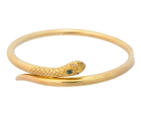 An early 20th century gold emerald and diamond snake bangle, set with rectangular shape emerald crest and old cut diamond eye