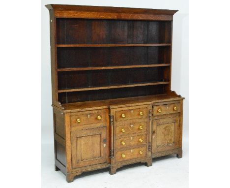 A c.1820 North Walian oak breakfront dresser with three shelves below a pediment, with shaped bracket, above base of four cen