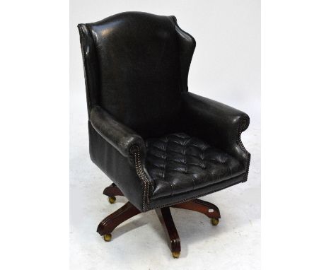 A Wade black leather revolving office chair with wing back and button pressed base, to castors. CONDITION REPORT: 20th centur