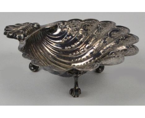 An Elizabeth II hallmarked silver scallop shaped dish with engraved floral and scroll decoration, raised on three outswept sc