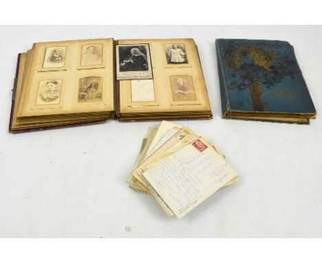A Victorian leather bound photograph album containing various portrait photographs, the pages with coloured printed decoratio