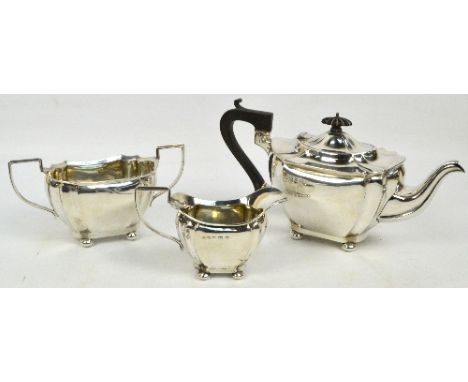 A George V hallmarked silver three piece tea service, comprising teapot of shaped oval form raised on four bun feet, length 3