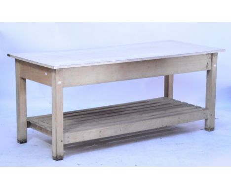 A vintage pine baker's table with straight square legs and lower tier of open planks, with Formica top, length 180cm, height 