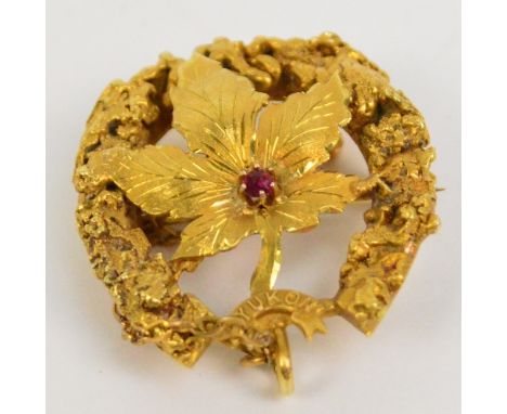 A.P. RENZONI; a yellow gold brooch centred with an engraved and pierced maple leaf set with ruby coloured stone, inscribed "Y