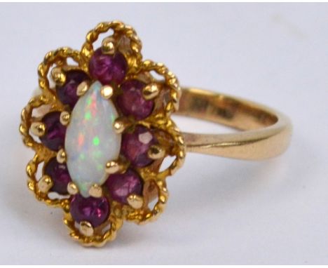 A 9ct yellow gold opal and ruby cluster ring, the central opal surrounded by eight rubies within a lobed wire frame, size K, 