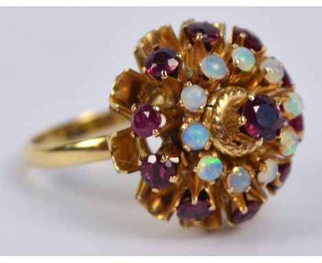 A yellow metal cluster ring with a circle of ten brilliant cut small rubies surrounding a circle of ten small cabochon opals 