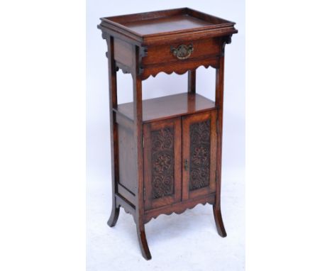 An unusual early 20th century smokers' cabinet with gallery top above frieze drawer, open section with two carved cupboard do