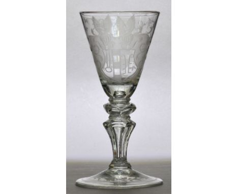 An early to mid 18th century Dutch light baluster, the conical bowl finely engraved with a double winged armorial centred wit