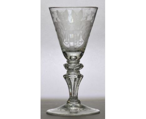 An early to mid 18th century Dutch light baluster, the conical bowl finely engraved with a double winged armorial centred wit