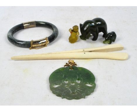 A jade bangle with yellow metal mount, a jadeite pendant, three carved animals, and a pair of glove stretchers (6).