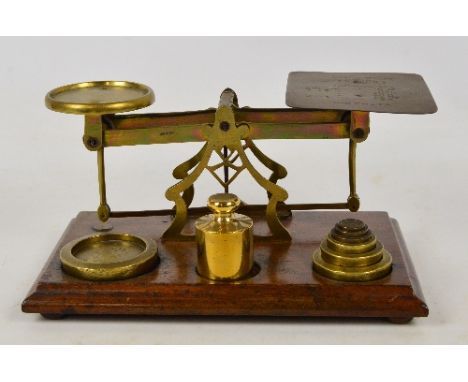 A pair of late Victorian brass Avery postal scales, on rectangular wooden plinth with various associated weights and postal r