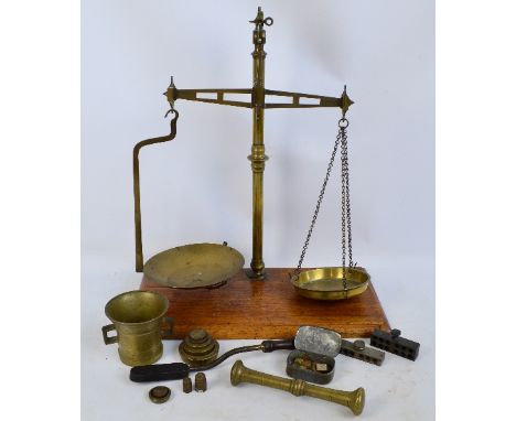 A set of brass beam scales, associated weights, two suppository pill moulds, and a gas operated wooden handled tool.