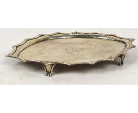 A George III hallmarked silver teapot stand of shaped oval form, engraved R to the centre, with bright cut decorated rim, rai