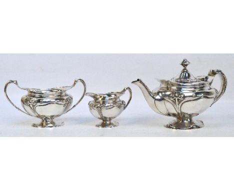 An Edward VII hallmarked silver Art Nouveau style three piece tea service comprising footed teapot of oval form with fluted h