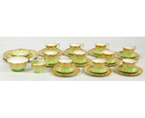 An Aynsley green and gilt heightened decorated tea service comprising ten trios, two spare saucers and one side plate, sugar 