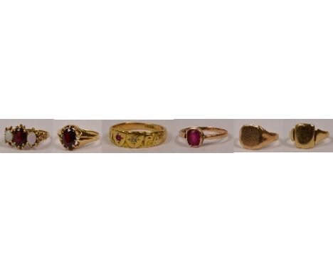 A group of six yellow gold rings including an opal and garnet three stone example, two gentleman's signet rings, and three ot