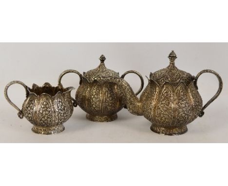 A c.1900 Indian white metal three piece tea service comprising teapot modelled as a lotus flower head with overall floral and