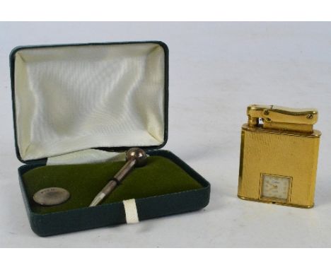A cased hallmarked silver golfer's set comprising tee and ball marker, and a Calibri Monopol lighter with built-in timepiece 