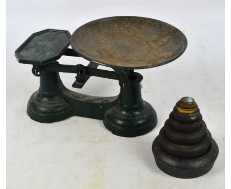 A set of painted cast iron kitchen scales with circular pan, and a set of nesting flat weights.