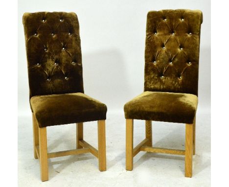 A contemporary set of eight gold button upholstered dining chairs raised on square section tapering legs.