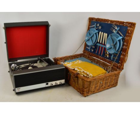 A wicker picnic hamper by Brexton containing cutlery and flatware, plates, knives and forks, food container boxes, etc, an em