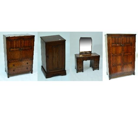 A four piece reproduction oak bedroom suite comprising wardrobe with hinged panel doors, with linen fold carving, enclosing h