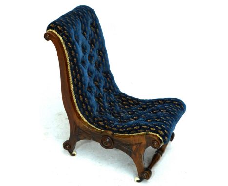 A Victorian simulated rosewood framed scroll back button upholstered nursing chair raised on shaped supports to castors.
