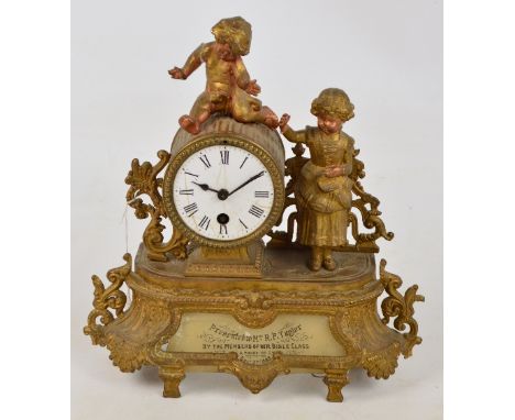 A 19th century gilt heightened spelter mantel clock decorated with cherubic type figures, the enamel dial set with Roman nume