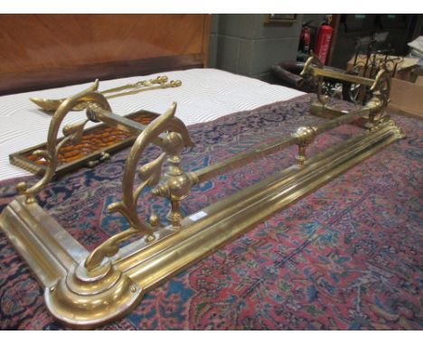 An Art Nouveau brass fender together with a moulded glass firescreen, two fire irons and another extending fender (5)  