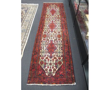 A Turkish red and blue runner with a cream field, 310 x 86cm  