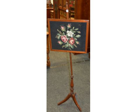 A late Victorian mahogany firescreen pole with cross stictched panel depicting flowering roses