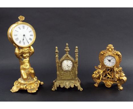 Gilt metal drumhead clock timepiece with platform escapement, the 3.25" white dial held aloft by a cherub seated upon an orna