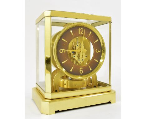 Jaeger LeCoultre Atmos clock, the 5" brown chapter ring enclosing a skeletonised centre, within a gilded brass canted glazed 
