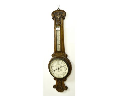Oak wheel aneroid barometer and thermometer, within a foliate carved case