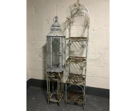 A large hurricane lamp together with a nest of two metal plant stands and a metal four tier whatnot stand