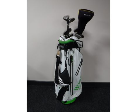 A Hugo Boss golf bag containing a set of Slazenger golf clubs and a pair of army desert books
