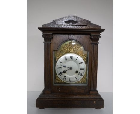 An early twentieth century oak cased mantel clock with brass and silvered dial 