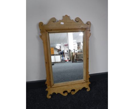 An antique pine Chippendale style mirror together with an oval mahogany bevelled edge mirror