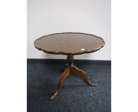 A walnut tilt top pie crust edge occasional table on a tripod base