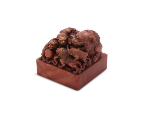 A Chinese soapstone seal, the finial carved with a Buddhist lion and its cubs, the seal face with fourteen characters in seal