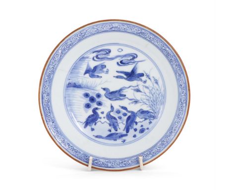A Chinese blue and white saucer dish, 17th century, centrally painted with ducks, scroll border with brown line rim, the base