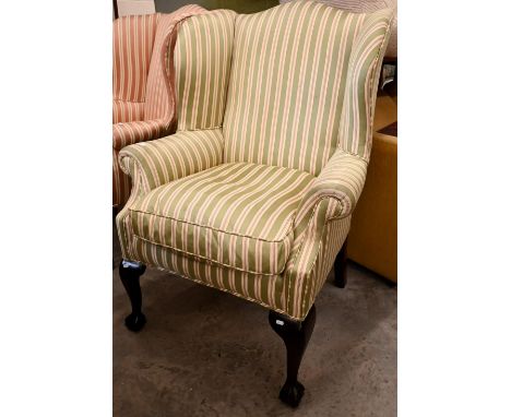 A Georgian style mahogany framed wingback armchair with green and cream striped fabric and cabriole front legs with ball and 