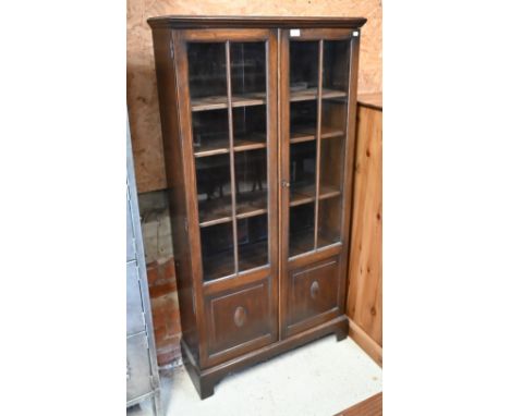 An oak two door bookcase with glazed and panelled front, on bracket feet, 80 x 30 x 154 cm high 