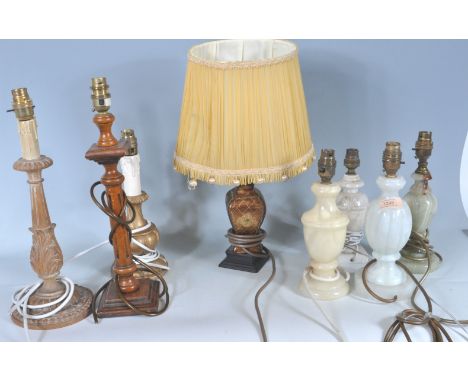 A collection of 20th century antique style table lamp bases to include carved marble bases, alabaster lamp bases, wooden turn