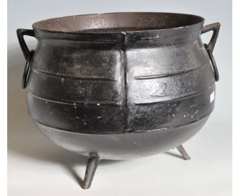 A vintage 20th century ebonised cast iron pot / cauldron of globular form having carry handles to the side raised on three an