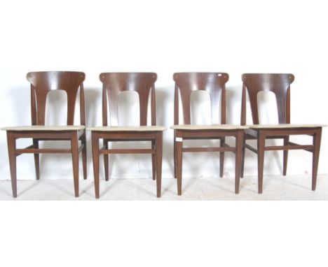 A set of four vintage retro stained teak dining chairs having pierced backrests raised on turned supports with tapering turne